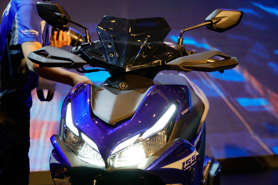 Điểm thay đổi dễ nhận thấy trên NVX 155 phiên bản mới là thiết kế mềm mại hơn ở phần đầu xe. Ngoài ra, Yamaha đã bổ sung thêm cho mẫu xe này một khe hút gió nhỏ ở vị trí trung tâm. Phần quây gió 2 bên cũng có thêm khe thoát gió.(Ảnh: Minh Hiếu/Vietnam+)
