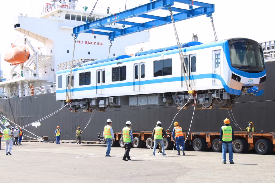 Toa xe đầu tiên của đoàn tàu số 4 được cẩu khỏi tàu vận chuyển Pulang Tala và đặt xuống xe chuyên dụng. (Ảnh: Tiến Lực/TTXVN)