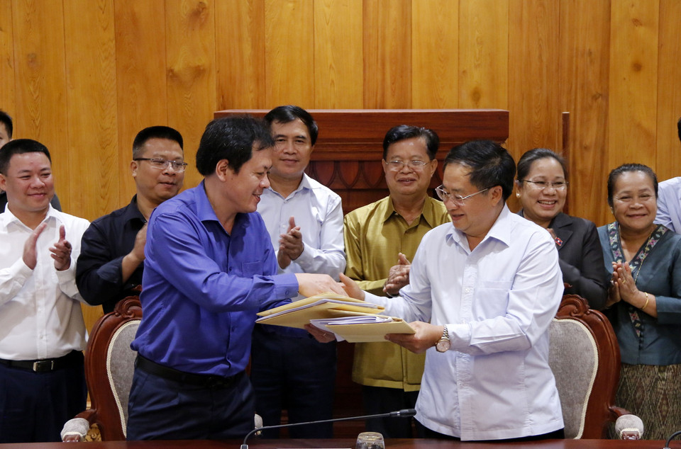 Đại diện Chủ đầu tư (trái) và Đại diện Ban Quản lý dự án xây dựng Nhà Quốc hội mới của Lào đang trao cho nhau Biên bản nghiệm thu các hạng mục phục vụ cho kỳ họp thứ nhất Quốc hội khóa 9 của Lào. (Ảnh: Phạm Kiên/Vietnam+)