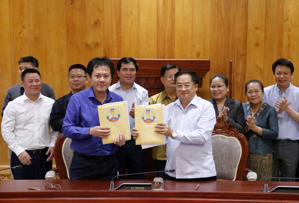 Đại diện Chủ đầu tư (trái) và Đại diện Ban Quản lý dự án xây dựng Nhà Quốc hội mới của Lào đang trao cho nhau Biên bản nghiệm thu các hạng mục phục vụ cho kỳ họp thứ nhất Quốc hội khóa 9 của Lào. (Ảnh: Phạm Kiên/Vietnam+)