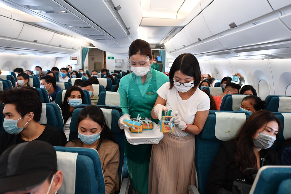 Chị Đặng Thị Hương - thành viên sáng lập HopeBox tham gia tặng quà trên chuyến bay. (Ảnh: CTV/Vietnam+)