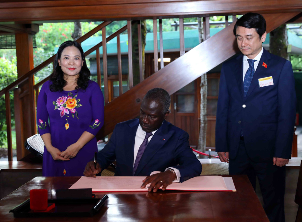 Chủ tịch Quốc hội Cộng hòa Bờ Biển Ngà Adama Bictogo ghi sổ lưu bút tại Nhà sàn Bác Hồ trong khu Di tích Chủ tịch Hồ Chí Minh. (Ảnh: An Đăng/TTXVN)