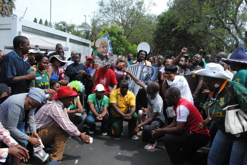 Người dân Nam Phi cầu nguyện cho ông Mandela trước cửa nhà riêng của ông ở Houghton, Johannesburg. (Ảnh: Nguyễn Đức/Vietnam+)