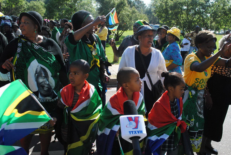 Người dân Nam Phi khoác quốc kỳ Nam Phi chờ vào viếng ông Mandela. (Ảnh: Nguyễn Đức/Vietnam+)