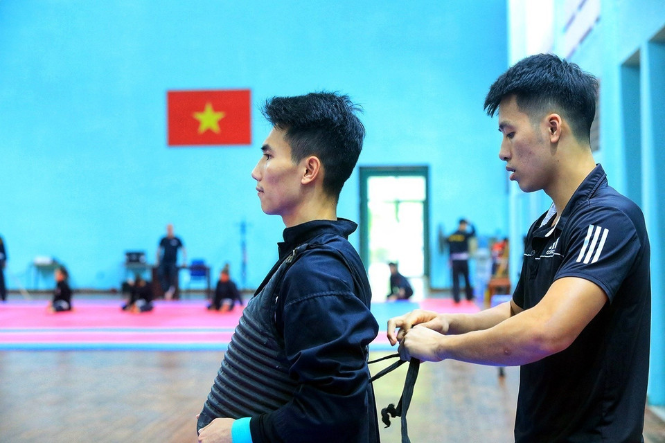 Các vận động viên đeo áo giáp trước khi tập luyện. (Ảnh: Tuấn Anh/TTXVN)