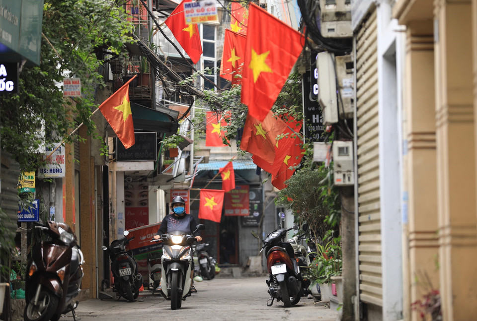 Các hộ dân trên phố Hàng Đào (Hoàn Kiếm) treo cờ tổ quốc chào đón năm mới 2022. (Ảnh: Hoàng Hiếu/TTXVN)