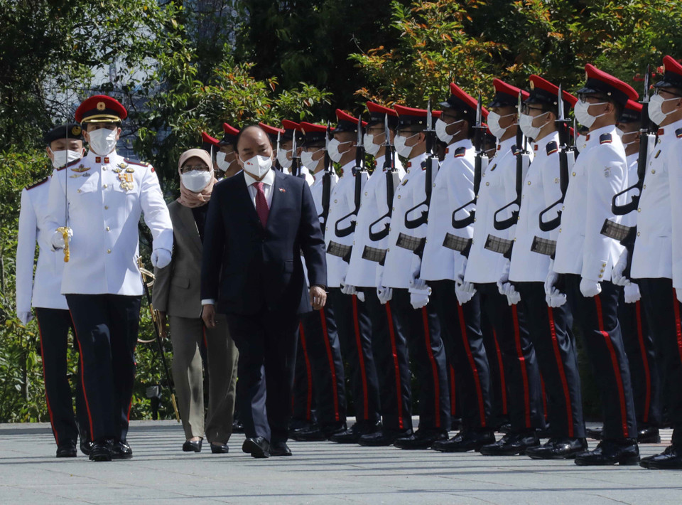 Chủ tịch nước Nguyễn Xuân Phúc và Tổng thống Cộng hòa Singapore Halimah Yacob duyệt đội danh dự. (Ảnh: Thống Nhất/TTXVN)