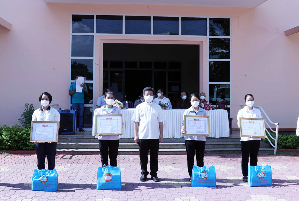Linh mục Giuse Đào Nguyên Vũ, Chánh văn Phòng Hội đồng Giám mục Việt Nam trao giấy biểu dương tri ân các tình nguyện viên tôn giáo đã hoàn thành nhiệm vụ. (Ảnh: Xuân Khu/TTXVN)