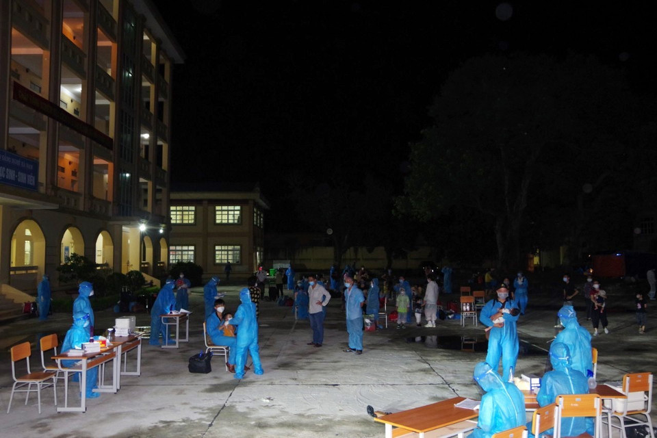 Sau khi xuống ôtô, các công dân trở về từ Thành phố Hồ Chí Minh chờ lấy xét nghiệm, sàng lọc tại điểm cách ly tập trung trường Cao đẳng Y tế Hà Nam. (Ảnh: Đại Nghĩa/TTXVN)