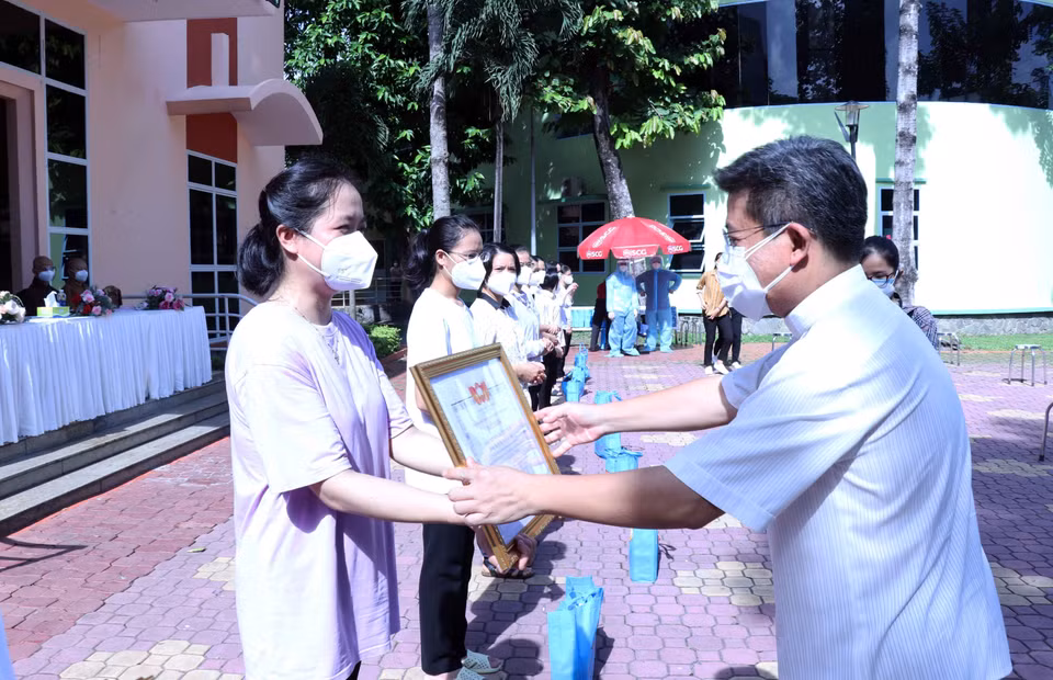 Linh mục Giuse Đào Nguyên Vũ, Chánh văn Phòng Hội đồng Giám mục Việt Nam trao giấy biểu dương tri ân các tình nguyện viên tôn giáo đã hoàn thành nhiệm vụ. (Ảnh: Xuân Khu/TTXVN)