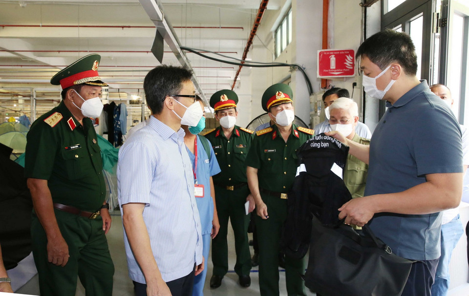 Phó Thủ tướng Vũ Đức Đam kiểm tra công tác chuẩn bị hoạt động sản xuất, kinh doanh sau khi nới lỏng tại Công ty liên doanh may mặc Hàn Quốc. (Ảnh: Hồng Pha/TTXVN phát)