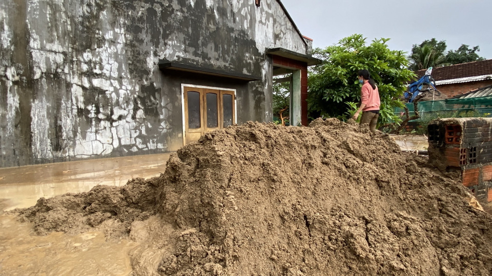  Chị Đặng Thị Hiền cố sức nạo vét bùn đất trôi vào nhà. (Ảnh: Tường Quân/TTXVN)