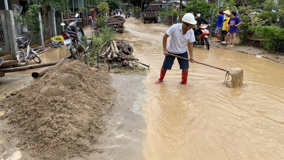 Người dân nạo vét bùn đất trên đường bêtông. (Ảnh: Tường Quân/TTXVN)