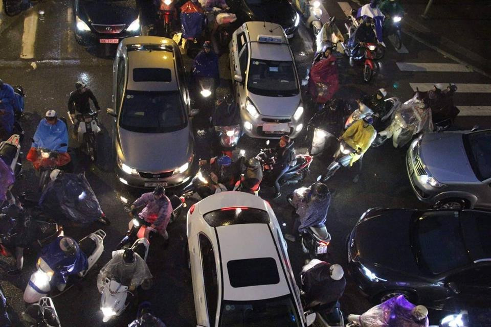 Những chiếc xe máy 'vắt ngang' mặt ôtô để kịp về nhà khiến đường càng thêm tắc. (Ảnh: PV)