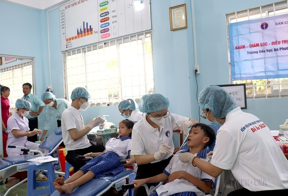 Bệnh viện Răng Hàm Mặt Trung ương Thành phố Hồ Chí Minh phối hợp với Sở Y tế, Sở Giáo dục và Đào tạo tỉnh Vĩnh Long tổ chức chương trình khám, chăm sóc, điều trị và giáo dục sức khỏe răng miệng cho học sinh Trường Tiểu học An Phước A (xã An Phước, huyện Mang Thít, tỉnh Vĩnh Long), tháng 12/2022. (Ảnh: Thuý Hằng/TTXVN)