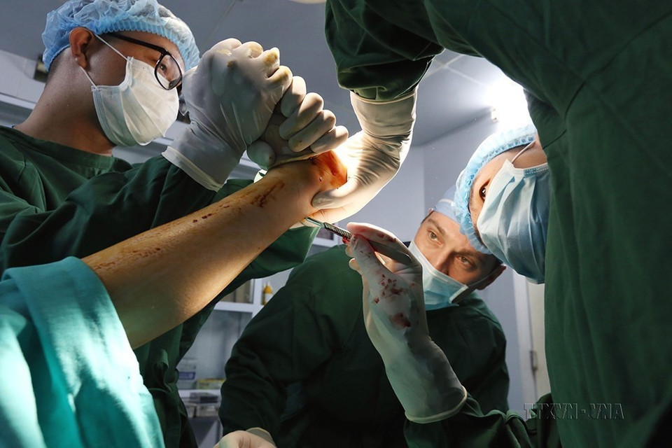 Chuyên gia Mỹ cùng với các bác sỹ của Bệnh viện chỉnh hình và phục hồi chức năng Hà Nội phẫu thuật cho bệnh nhân tàn tật. (Ảnh: Anh Tuấn/TTXVN)