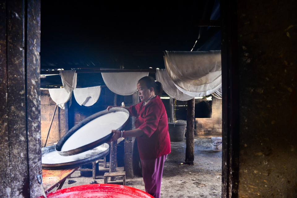 Bột được đổ vào các khuôn lớn, sau đó đem đi hấp chín trực tiếp trong các nồi nước sôi. (Ảnh: Nam Thái/TTXVN)