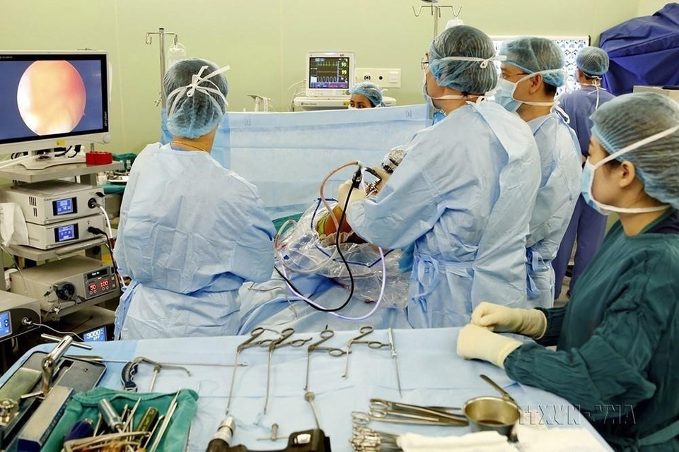 Chuyên gia Pháp cùng các bác sỹ, kỹ thuật viên khoa Chấn thương chỉnh hình và Cột sống - Bệnh viện Bạch Mai thực hiện các kỹ thuật hiện đại trong phẫu thuật nội soi tái tạo dây chằng khớp gối. (Ảnh: Dương Ngọc/TTXVN)