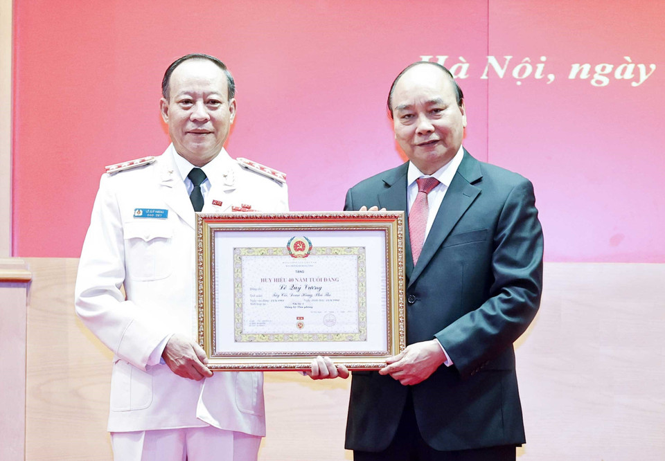 Chủ tịch nước Nguyễn Xuân Phúc trao tặng Huy hiệu 40 năm tuổi Đảng cho Thượng tướng Lê Quý Vương, nguyên Ủy viên Trung ương Đảng, nguyên Thứ trưởng Bộ Công an. (Ảnh: Thống Nhất/TTXVN)