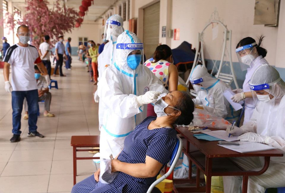 Lực lượng y tế lấy mẫu xét nghiệm COVID-19 cho tiểu thương chợ Hà Đông, sáng 24/8. (Ảnh: Hoàng Hiếu/TTXVN)