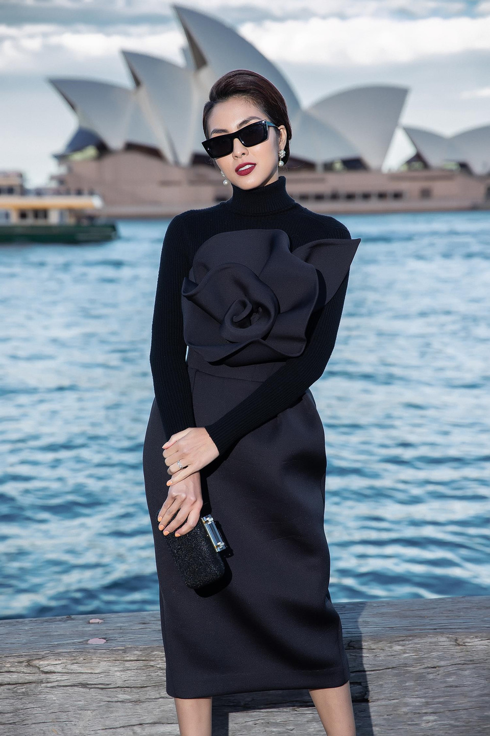 Nữ diễn viên Tăng Thanh Hà mang đến vẻ ngoài sang trọng, quyến rũ với thiết kế cúp ngực ôm sát được tạo điểm nhấn với hoạ tiết nơ hoa hồng 3D to bản. Trang phục trở nên lạ mắt khi được phối cùng áo cổ lọ bên trong, phù hợp với tiết trời đang trở lạnh của Sydney. (Ảnh: Diệu Linh/Vietnam+)