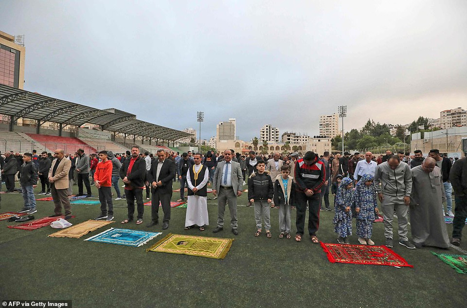 Các tín đồ phải bảo đảm giãn cách xã hội khi cầu nguyện ở bên ngoài. Ảnh: Tín đồ cầu nguyện tại sân vận động Hussein Bin Ali ở Hebron, khu Bờ Tây. (Nguồn: Daily Mail)