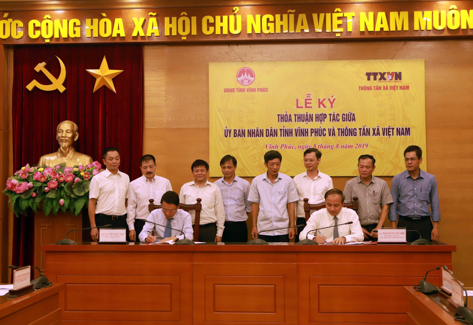 Tổng Giám đốc Thông tấn xã Việt Nam Nguyễn Đức Lợi (trái) và Phó Bí thư Tỉnh ủy, Chủ tịch UBND tỉnh Vĩnh Phúc Nguyễn Văn Trì ký thỏa thuận hợp tác. (Ảnh: Hoàng Hùng/TTXVN)