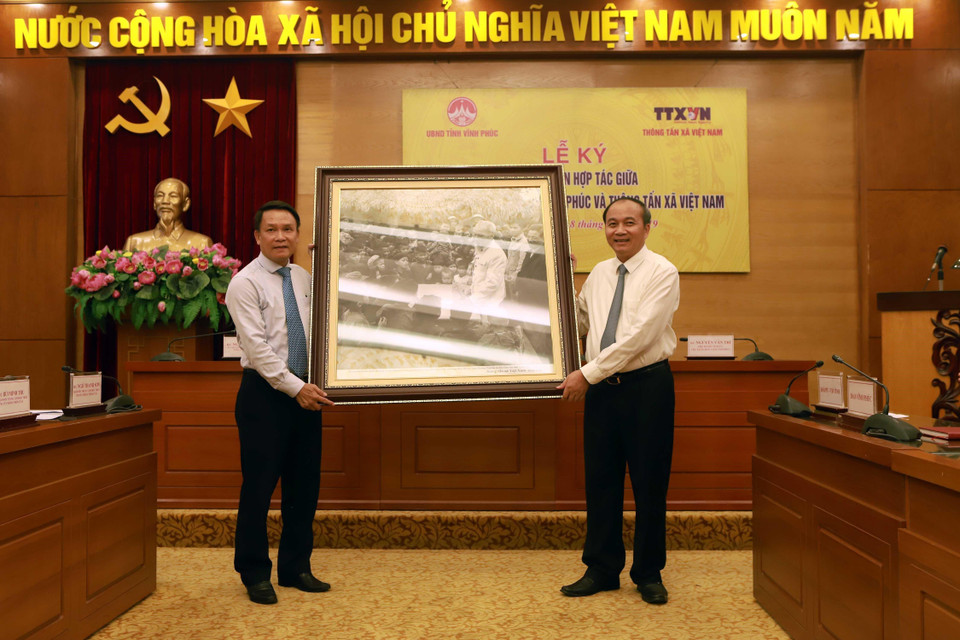 Tổng Giám đốc Thông tấn xã Việt Nam Nguyễn Đức Lợi (trái) tặng tranh cho Phó Bí thư Tỉnh ủy, Chủ tịch UBND tỉnh Vĩnh Phúc Nguyễn Văn Trì. (Ảnh: Hoàng Hùng/TTXVN)
