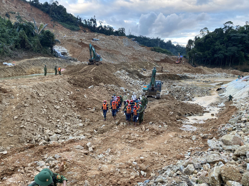 Lực lượng chức năng đưa thi thể nạn nhân ra khỏi hiện trường. (Ảnh: TTXVN phát)