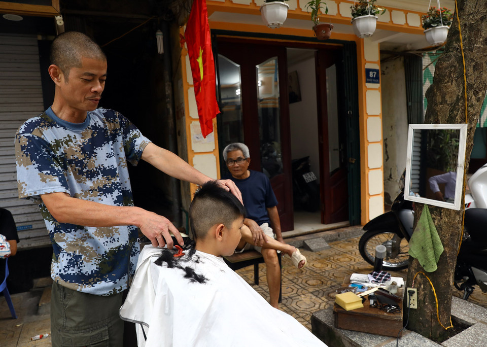 Tiệm cắt tóc trên phố Trúc Bạch hoạt động trở lại sau 14 ngày cách ly. (Ảnh: Huy Hùng/TTXVN)