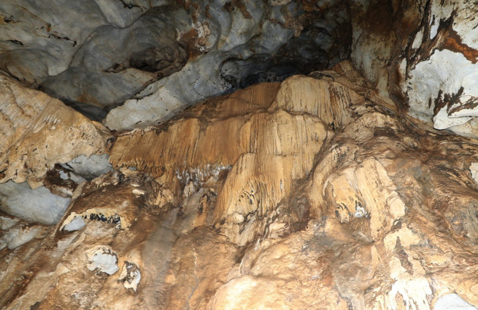 Những rèm nhũ đá có màu sắc vàng óng trên vách khoang trong hang động Hắt Chuông. (Ảnh: Xuân Tiến/TTXVN)