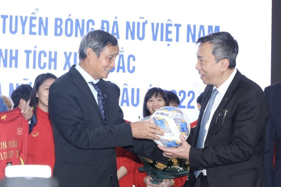 Huấn luyện viên trưởng đội tuyển bóng đá nữ Việt Nam Mai Đức Chung trao tặng đại diện Liên đoàn bóng đá Việt Nam trái bóng và chiếc áo đấu của đội tuyển tại giải Bóng đá vô địch châu Á 2022 tại Ấn Độ. (Ảnh: Minh Quyết/TTXVN)