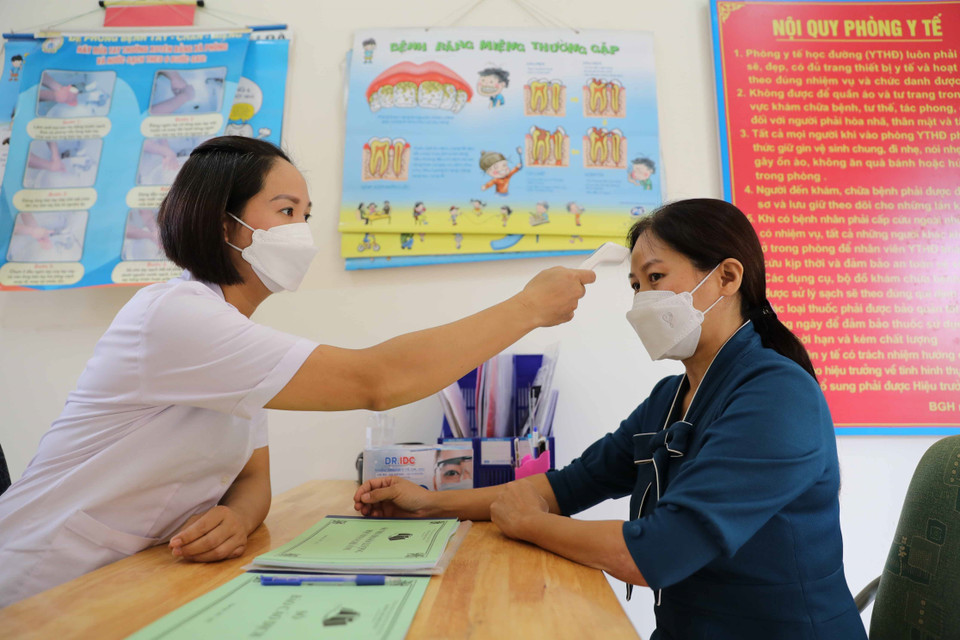 Trường Tiểu học Dị Nậu, huyện Thạch Thất sẽ phối hợp với Đoàn Thanh niên để đón học sinh trong những ngày đầu, đảm bảo các em được đo thân nhiệt nhanh chóng trước khi vào lớp, tránh bị ùn ứ tại cổng trường. (Ảnh: Thanh Tùng/TTXVN)