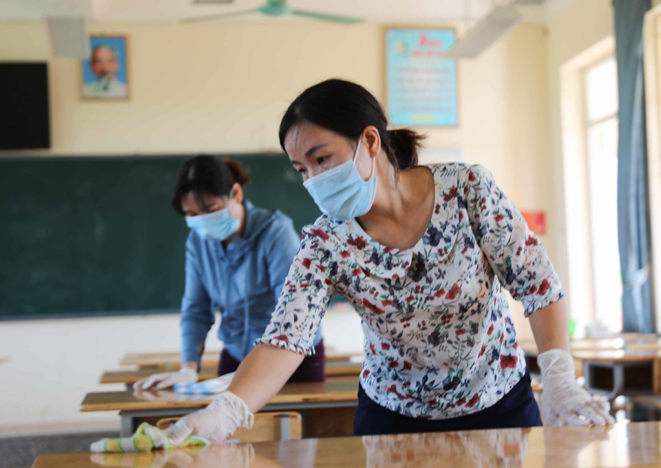 Giáo viên trường THCS Chàng Sơn, huyện Thạch Thất vệ sinh lớp học chuẩn bị đón học sinh trở lại trường. (Ảnh: Thanh Tùng/TTXVN)