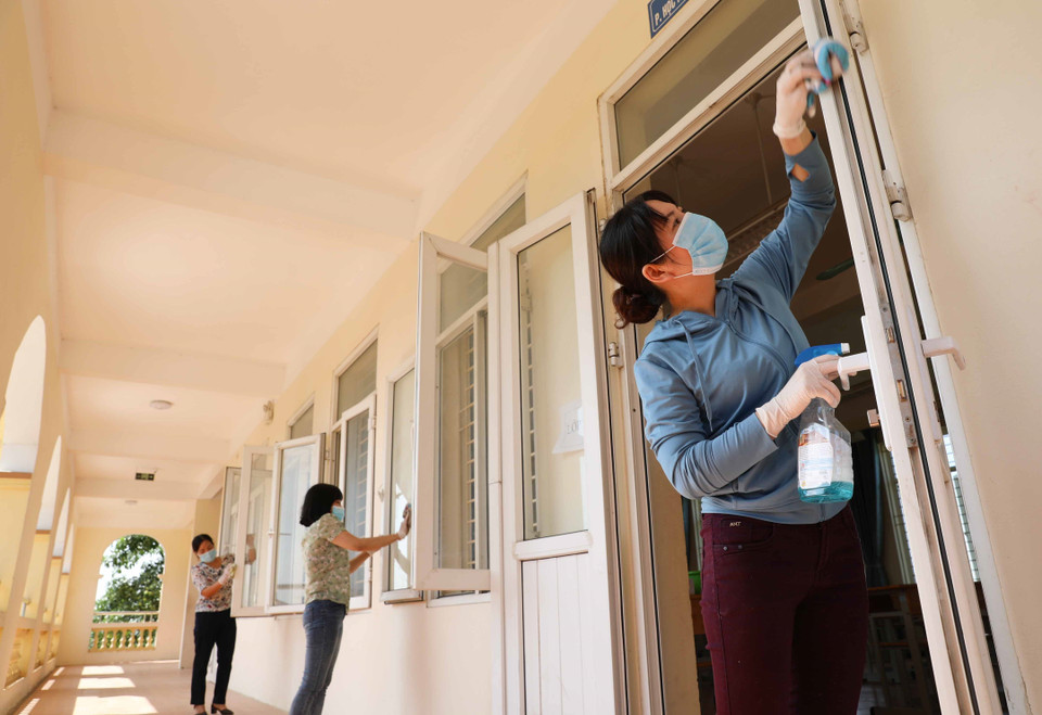 Giáo viên trường THCS Chàng Sơn, huyện Thạch Thất vệ sinh lớp học chuẩn bị đón học sinh trở lại trường. (Ảnh: Thanh Tùng/TTXVN)