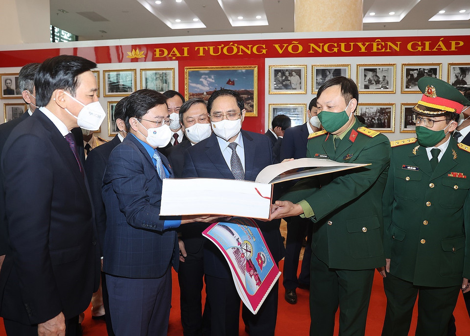 Thủ tướng Phạm Minh Chính và các đại biểu tham quan trưng bày ảnh và tư liệu, bài thi tìm hiểu về cuộc đời và sự nghiệp của Đại tướng Võ Nguyên Giáp. (Ảnh: Dương Giang/TTXVN)