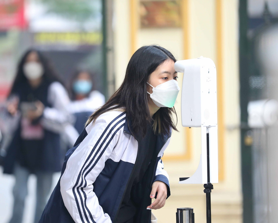 Học sinh trường THPT Việt Đức, quận Hoàn Kiếm thực hiện đo thân nhiệt, sát khuẩn tay khi tới tiêm mũi 2 vaccine phòng COVID-19 tại trường. (Ảnh: Thanh Tùng/TTXVN)