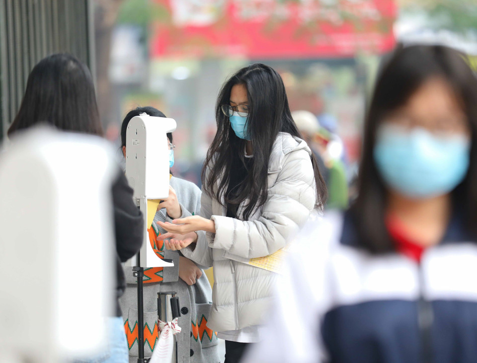 Học sinh trường THPT Việt Đức, quận Hoàn Kiếm thực hiện đo thân nhiệt, sát khuẩn tay khi tới tiêm mũi 2 vaccine phòng COVID-19 tại trường. (Ảnh: Thanh Tùng/TTXVN)