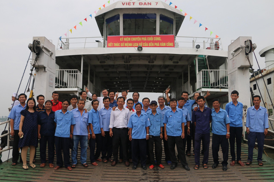 Tập thể cán bộ, công nhân lao động Bến phà Vàm Cống chụp hình kỷ niệm trên chuyến phà cuối cùng trước khi Bến phà Vàm Cống tạm dừng hoạt động. (Ảnh: Công Mạo/TTXVN)