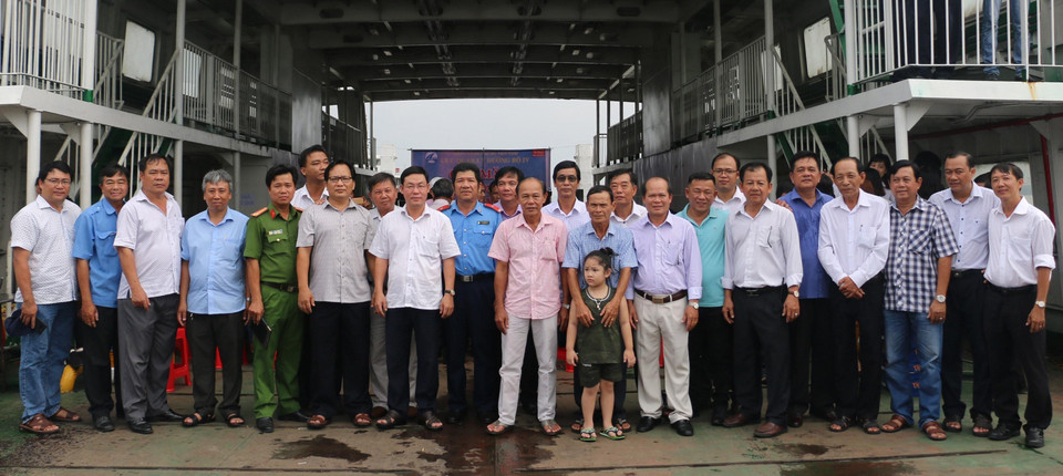 Tập thể lãnh đạo Bến phà Vàm Cống chụp hình kỷ niệm trên chuyến phà cuối cùng trước khi Bến phà Vàm Cống tạm dừng hoạt động.(Ảnh: Công Mạo/TTXVN)