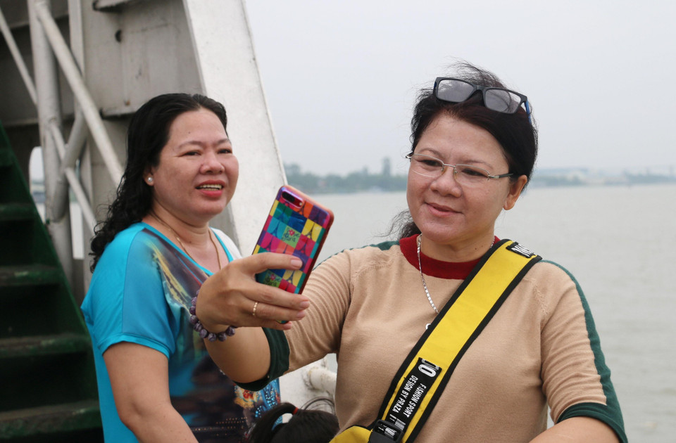  Người dân qua phà Vàm Cống vào sáng 30/6 tranh thủ ghi lại những hình ảnh cuối cùng trước khi Bến phà Vàm Cống tạm dừng hoạt động. (Ảnh: Công Mạo/TTXVN)