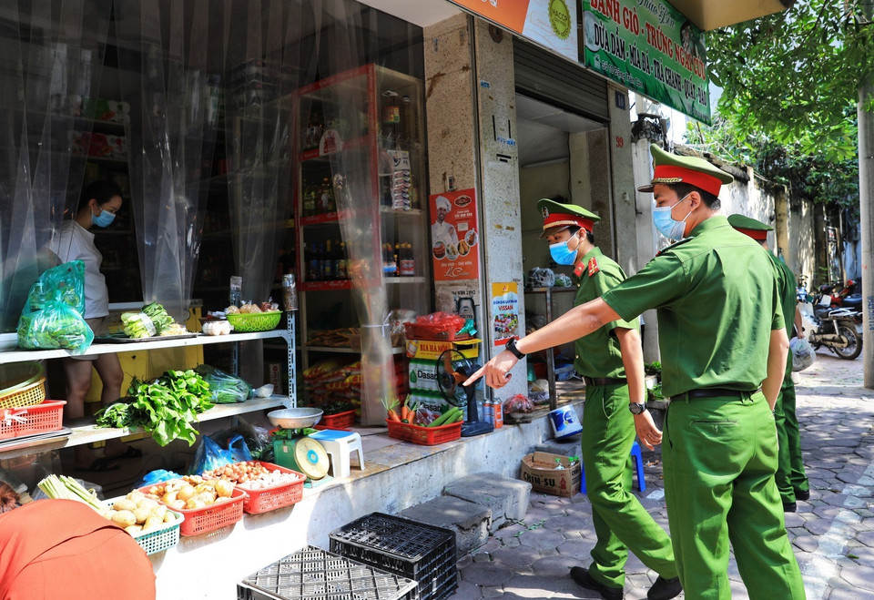 Lực lượng công an phường Quốc Tử Giám nhắc nhở các cửa hàng, quán ăn thực hiện đúng các biện pháp phòng, chống dịch bệnh COVID-19. (Ảnh: Thành Đạt/TTXVN)