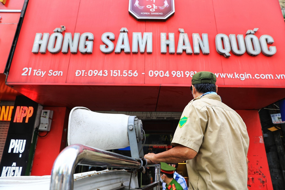  Lực lượng chức năng gọi loa yêu cầu cơ sở kinh doanh Hồng Sâm Hàn Quốc trên phố Nguyễn Lương Bằng đóng cửa. (Ảnh: Thành Đạt/TTXVN)