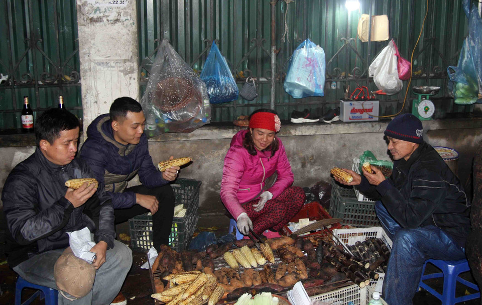 Một quầy hàng bán khoai lang, ngô nướng tại khu vực trường Đại học Bách Khoa Hà Nội thu hút rất đông khách trong những ngày rét đậm này. (Ảnh: Quang Quyết/TTXVN)