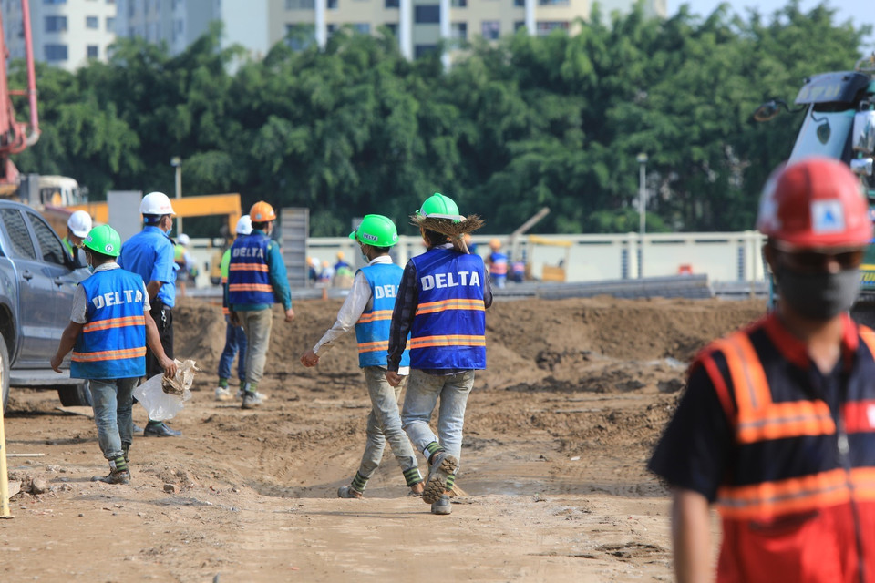 Các công nhân cùng các phương tiện cơ giới đang gấp rút thi công để đưa bệnh viện vào sử dụng. (Ảnh: Thành Đạt/TTXVN)