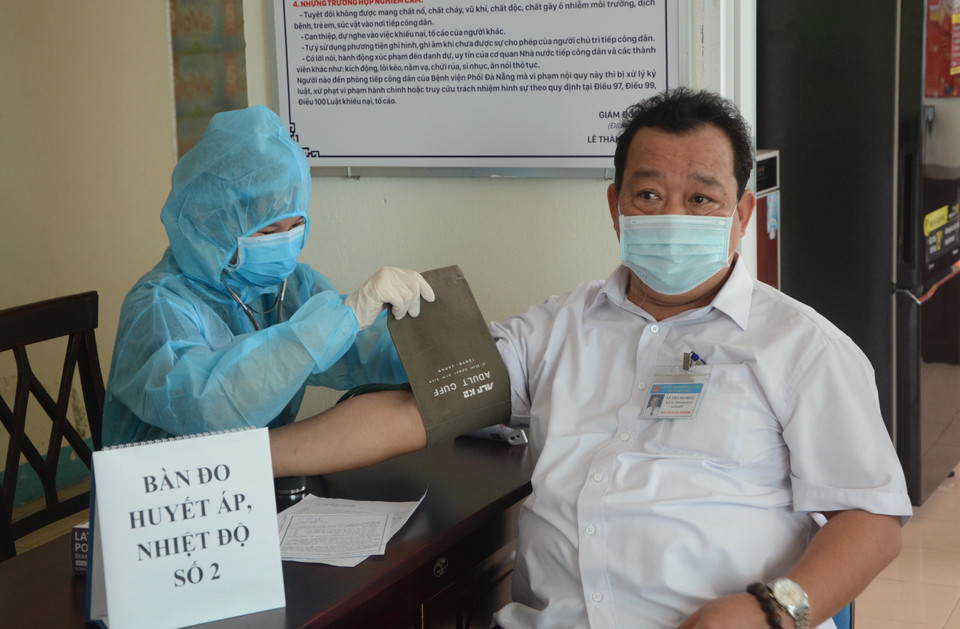 Nhân viên y tế khám sàng lọc cho người được tiêm. (Ảnh: Văn Dũng/TTXVN)