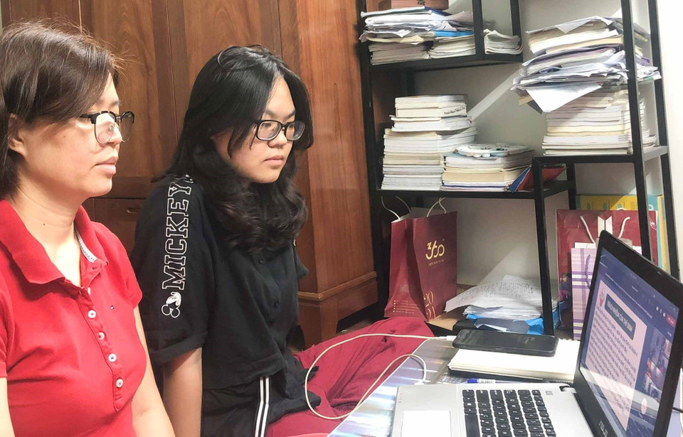 Phụ huynh cùng thí sinh tham gia buổi gặp gỡ, phổ biến quy chế thi trực tuyến trong tối 10/6. (Nguồn: TTXVN)