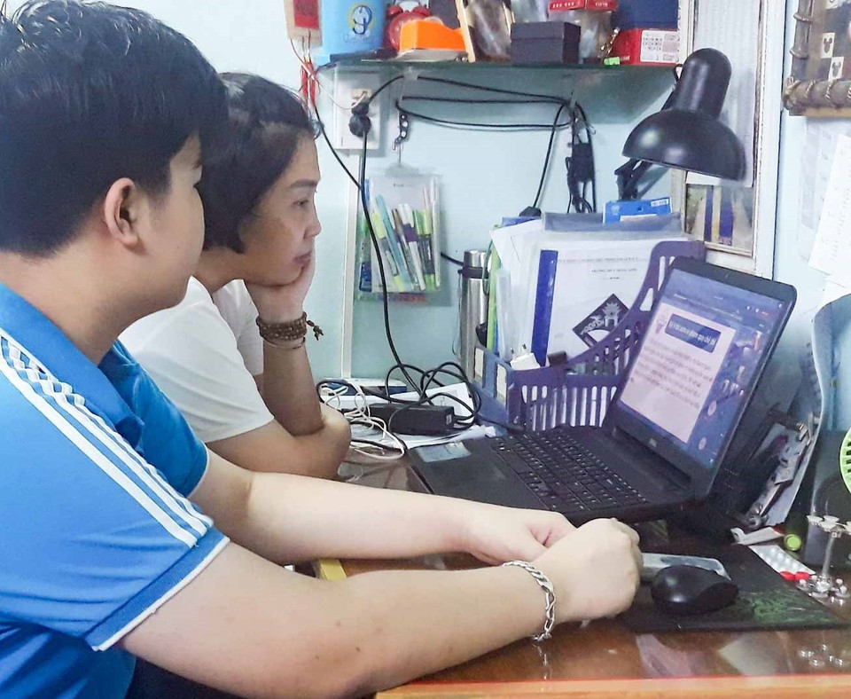 Phụ huynh cùng thí sinh tham gia buổi gặp gỡ, phổ biến quy chế thi trực tuyến trong tối 10/6. (Nguồn: TTXVN)