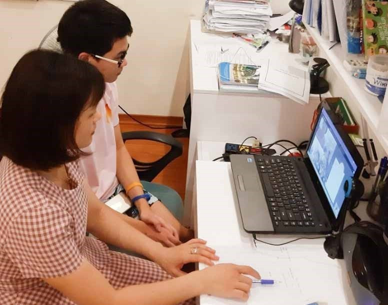 Phụ huynh cùng thí sinh tham gia buổi gặp gỡ, phổ biến quy chế thi trực tuyến trong tối 10/6. (Nguồn: TTXVN)