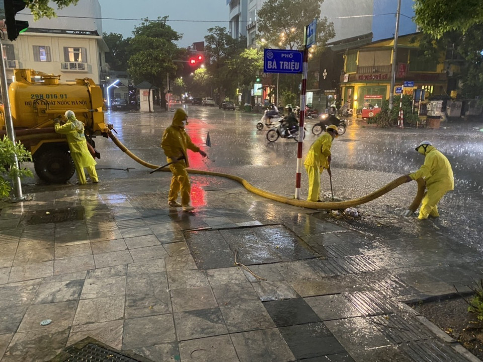 Công nhân Công ty Thoát nước Hà Nội triển khai các biện pháp chống ngập tại ngã 5 Bà Triệu - Nguyễn Du - Hồ Xuân Hương. (Ảnh: Mạnh Khánh/TTXVN)